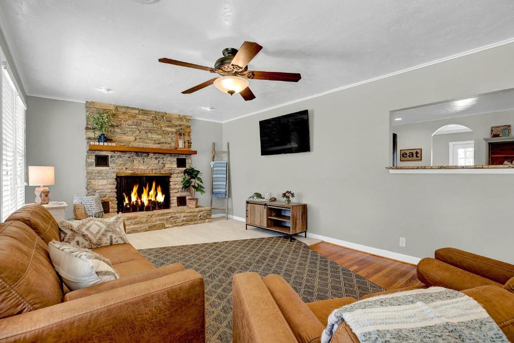 un salon avec un canapé et une cheminée dans l'établissement Bell Haus - Jacuzzi Tub Fire Pit Walk to Main St, à Fredericksburg