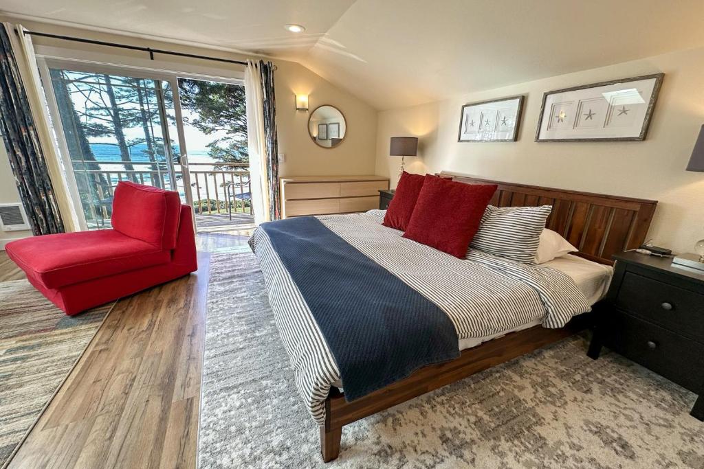 Searose BeachにあるOcean Front, Agate at Oregon House, Stairs to the Beach!のベッドと赤い椅子のある寝室