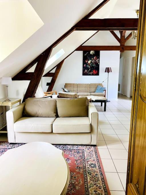 un salon avec un canapé blanc et une table dans l'établissement La Tsarine - Cottage - Château Le Bas Bleu, à Quesnoy-le-Montant