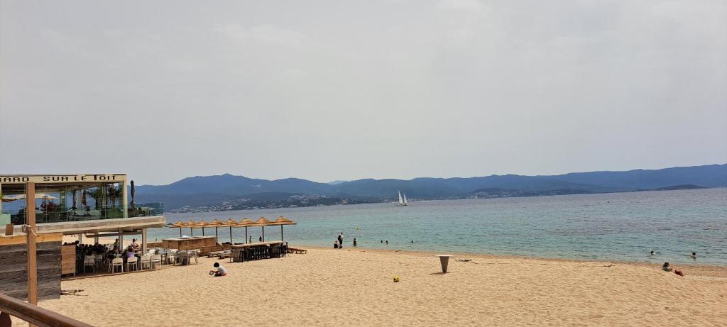 - une plage avec une jetée et des personnes sur l'eau dans l'établissement Charmant studio neuf Ajaccio Casone - Trottel, à Ajaccio