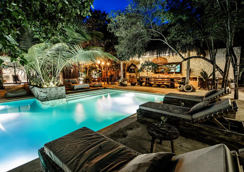 a swimming pool in a backyard with a house at Una Vida in Tulum