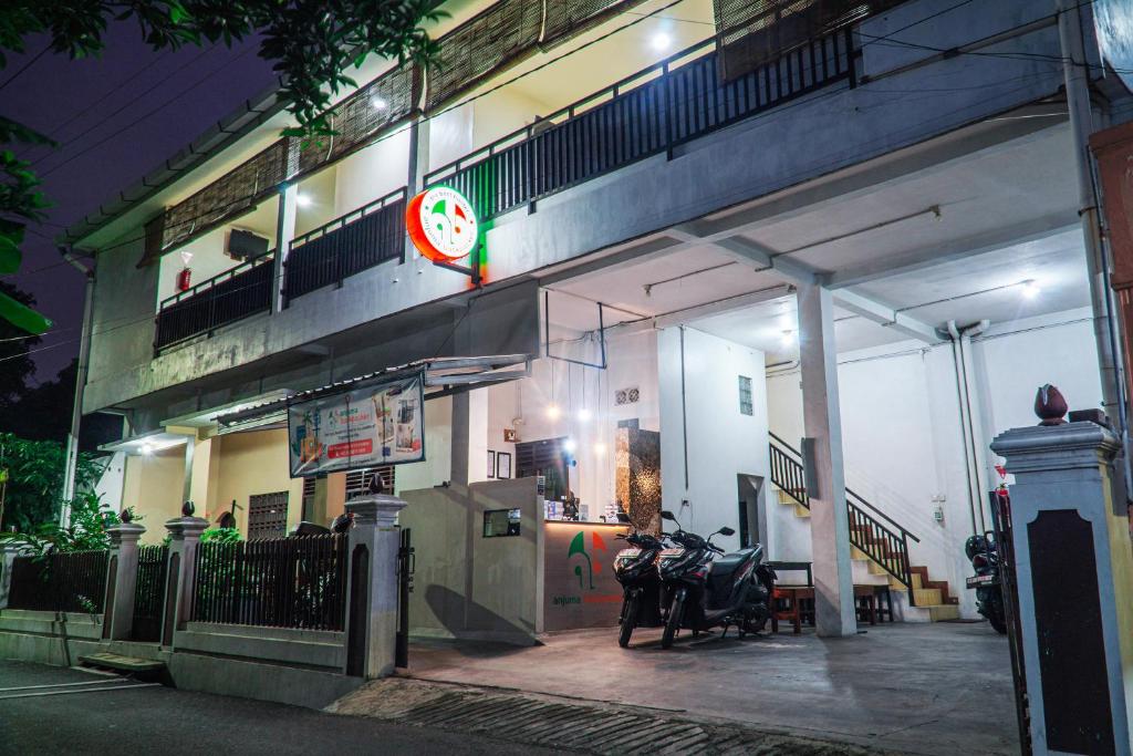 una moto parcheggiata fuori da un edificio di notte di Anjuma Backpacker a Yogyakarta