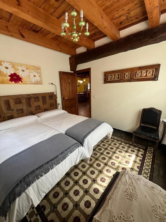 a bedroom with a large bed and a chandelier at El Salegar in Roturas