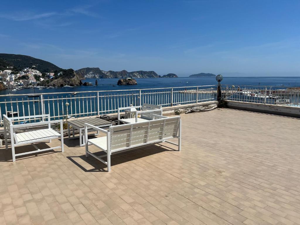 two benches sitting on a pier near the water at Agenzia Isotur ATTICO SUL PORTO in Ponza