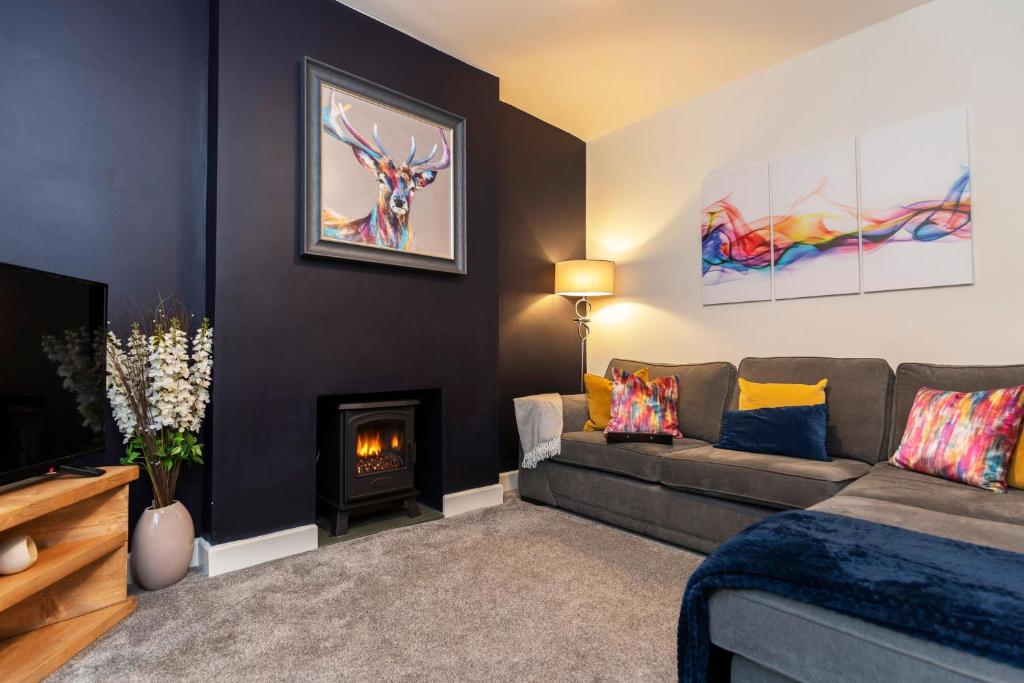 鲍内斯温德米尔Sheila's Cottage Bowness的带沙发和壁炉的客厅