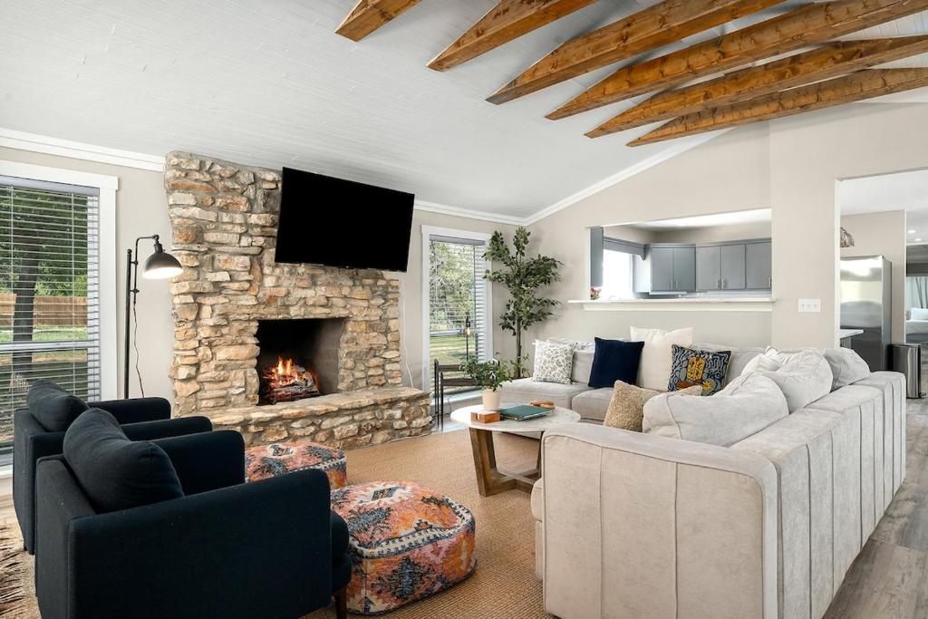 ein Wohnzimmer mit Couch und Kamin in der Unterkunft Hummingbird Haus - Sleeps 12 Cowboy Pool Firepit in Fredericksburg