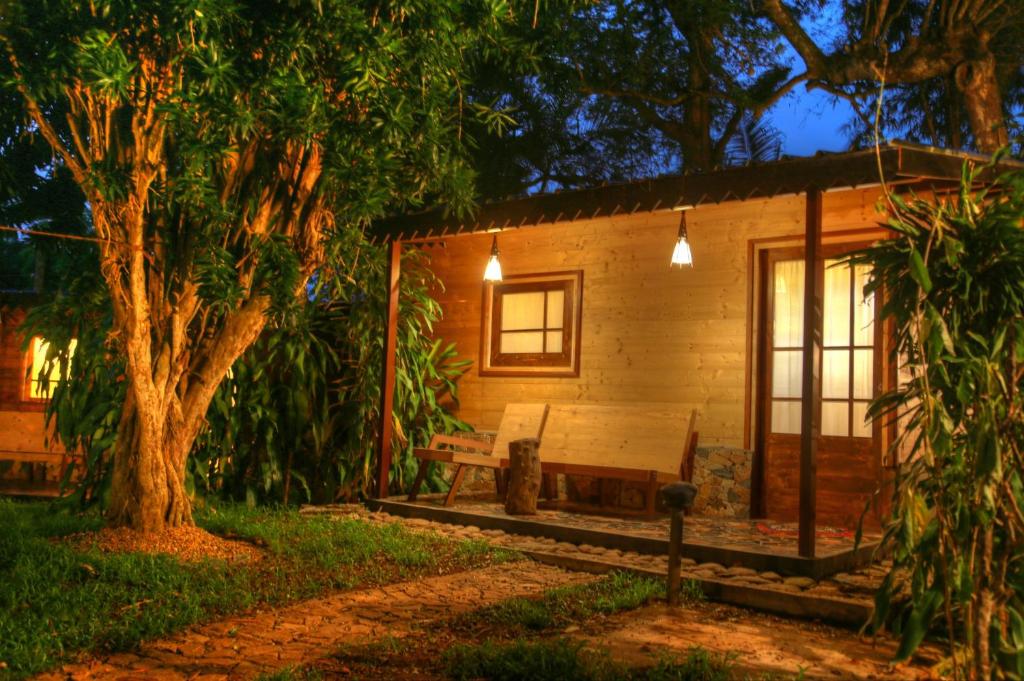 a wooden cabin with a bench and a tree at Beverly Hill Cabanas Hikkaduwa in Hikkaduwa