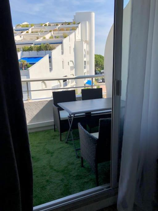 - un balcon avec vue sur une table et des chaises dans l'établissement Studio rénové, proche plage couchant, 4 pers, clim, parking privé et wifi privatif, à La Grande Motte