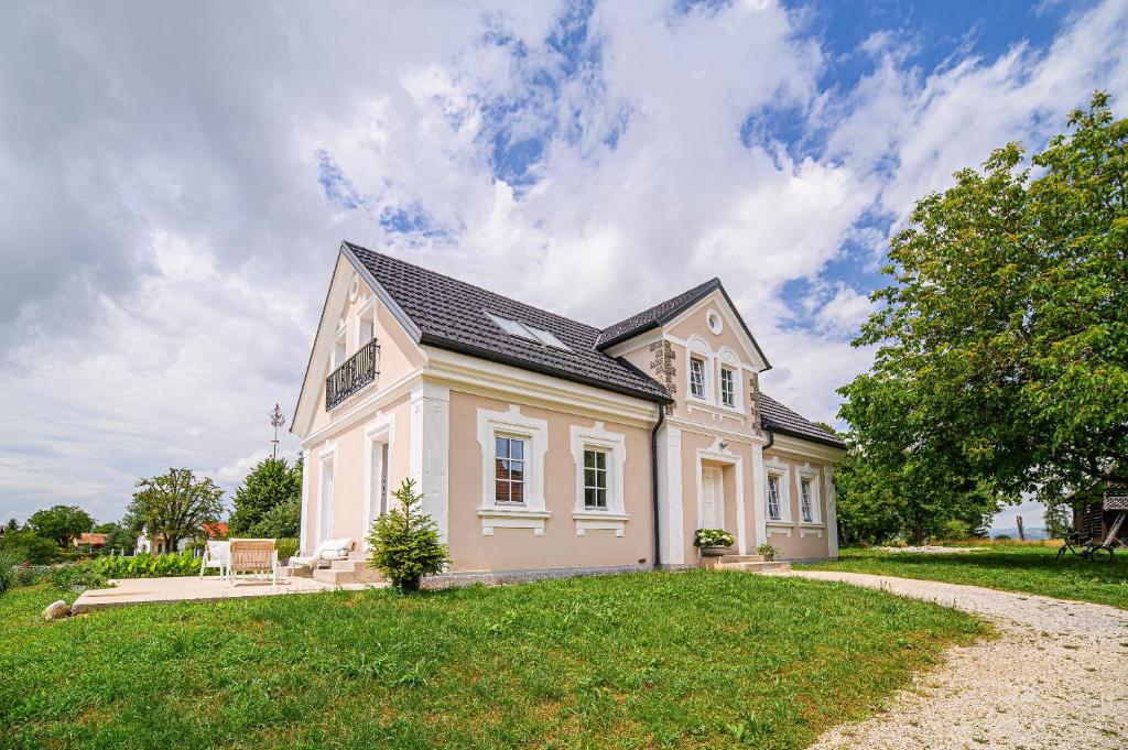 ein großes weißes Haus auf einem grünen Feld in der Unterkunft Holiday Home Evelin with Krka view in Cerklje ob Krki
