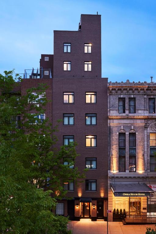 Un gran edificio de ladrillo con ventanas en el frente de un edificio. en The Melrose Hotel, en Bronx
