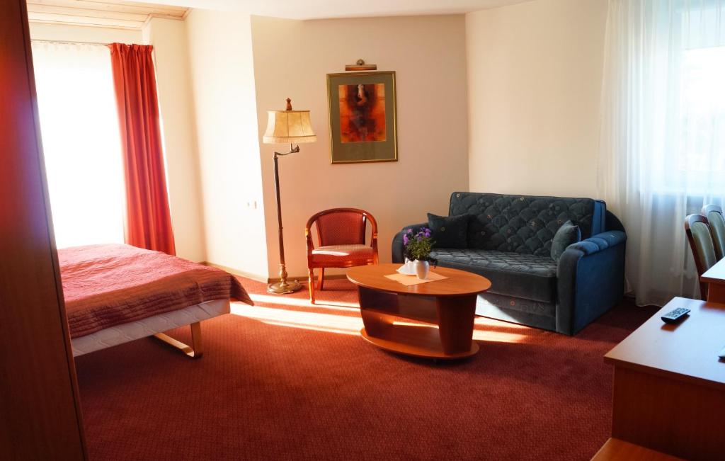 a hotel room with a bed and a couch at Motelis Smagratis Kretinga in Kretinga