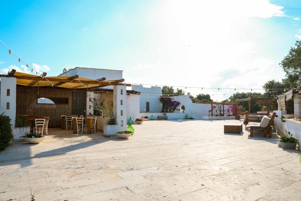 a patio with a table and chairs and an umbrella at Masseria Piccole Taverne in Rosa Marina