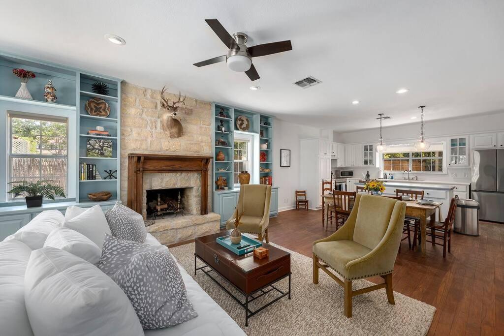 een woonkamer met een witte bank en een open haard bij Revins Haus - Fire Pit & Walk to Main St in Fredericksburg