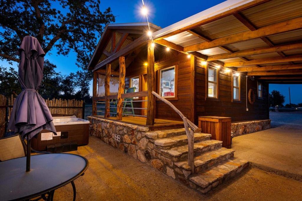 a log cabin with stairs and a table in front of it at Rockin' R - Morning Star Cabin in Fredericksburg