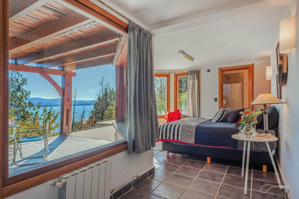 a bedroom with a bed and a large window at A3- Departamento con Vista Panorámica y Piscina in San Carlos de Bariloche