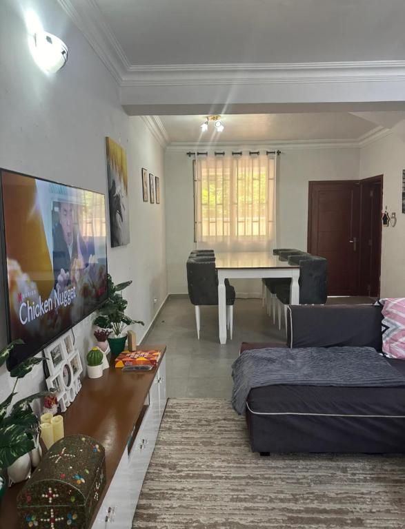 a living room with a tv and a couch and a table at Amazing home stays in Dar es Salaam