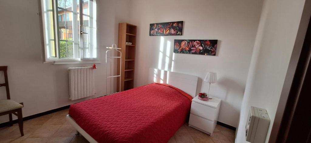 a bedroom with a red bed and a window at Casa Anna in Modena