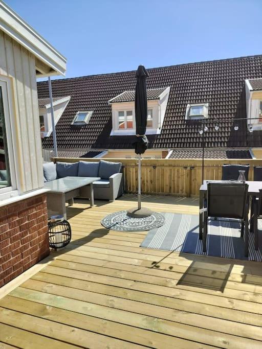 a wooden deck with an umbrella on a house at The terraced house in Stockholm