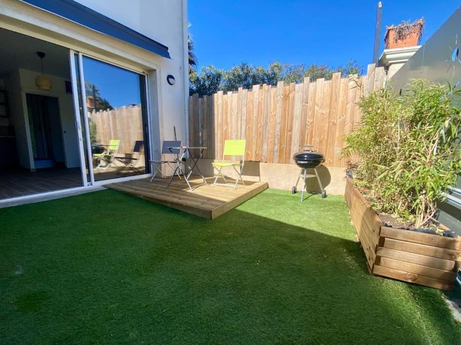une cour avec de l'herbe verte et une clôture dans l'établissement studio avec terrasse, à La Londe-les-Maures