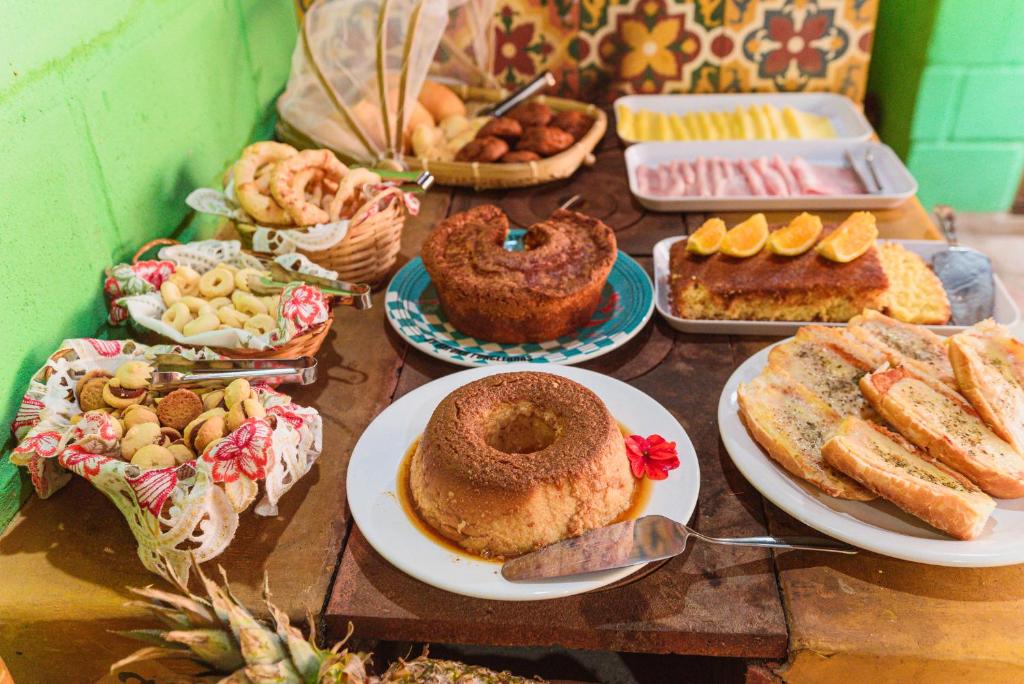 a table full of different types of bread and pastries at Pousada Casa de Fadas in Tiradentes