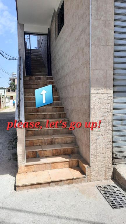a set of stairs with a blue sign on it at Crew Hostel Tirana in Tirana