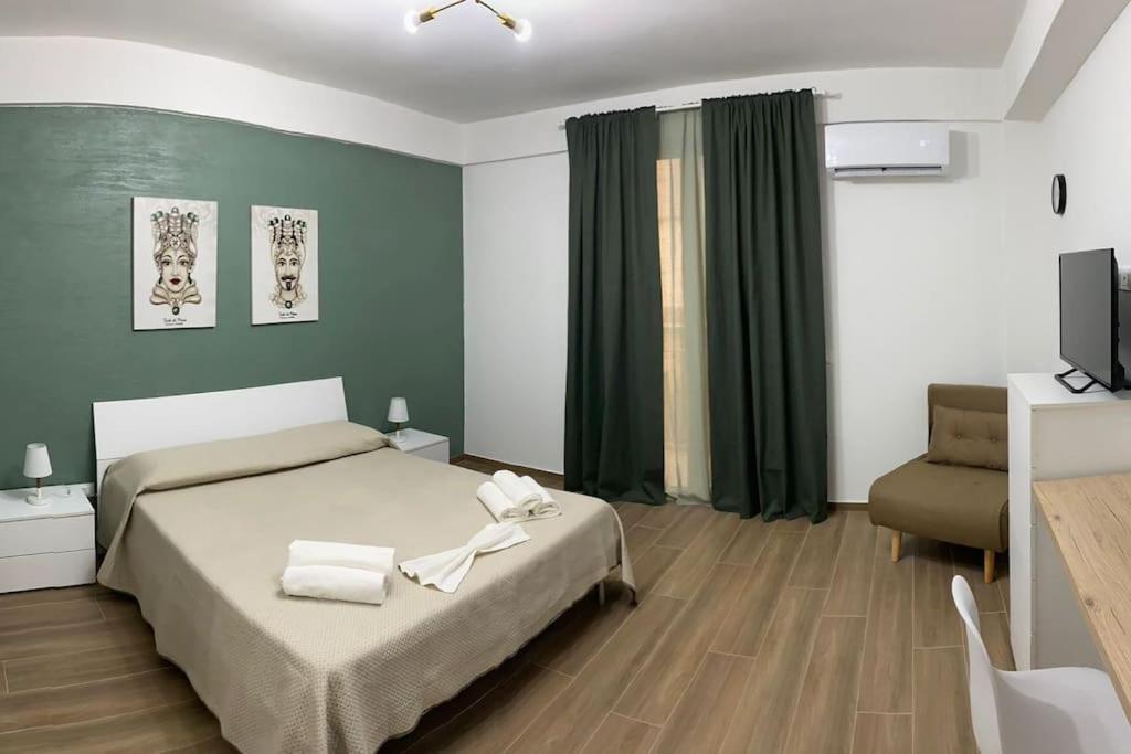 a bedroom with a bed and a television in it at Goodluck casa vacanza Avola in Avola