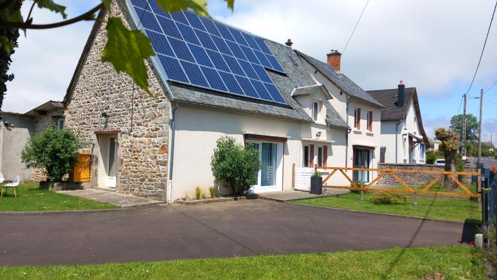 una casa con paneles solares en el techo en Gîte L'Instant Présent, en Messeix