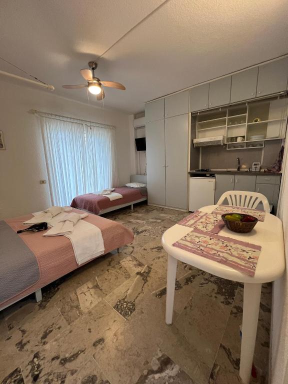 a bedroom with a bed and a table and a kitchen at Villa Katia in Asprovalta