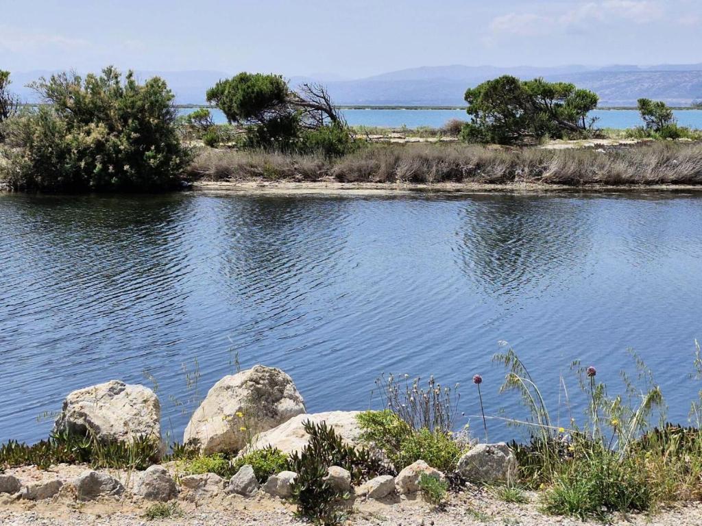 une grande étendue d'eau avec des rochers et des arbres dans l'établissement Résidence Hawai 1 - Maisonnette studio mezzanine 4 couchages - PORT LEUCATE MAE-7981, à Leucate