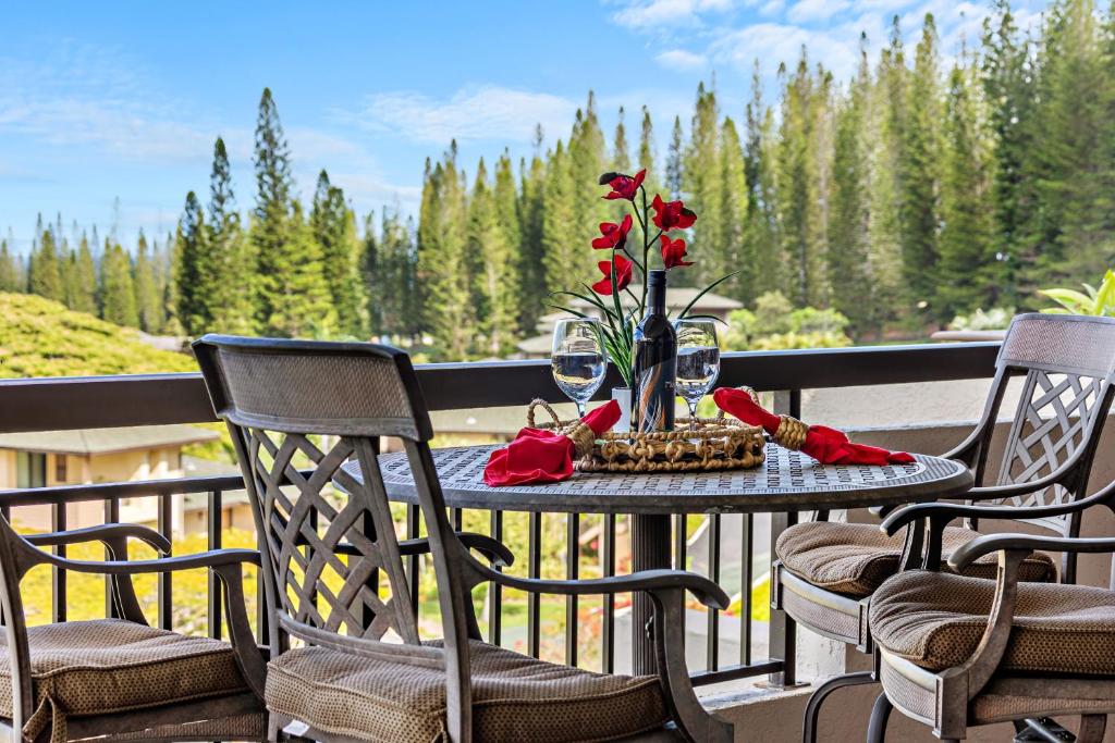 a table with a vase of flowers on a balcony at Kapalua Golf Villa 20V 1 in Kahana