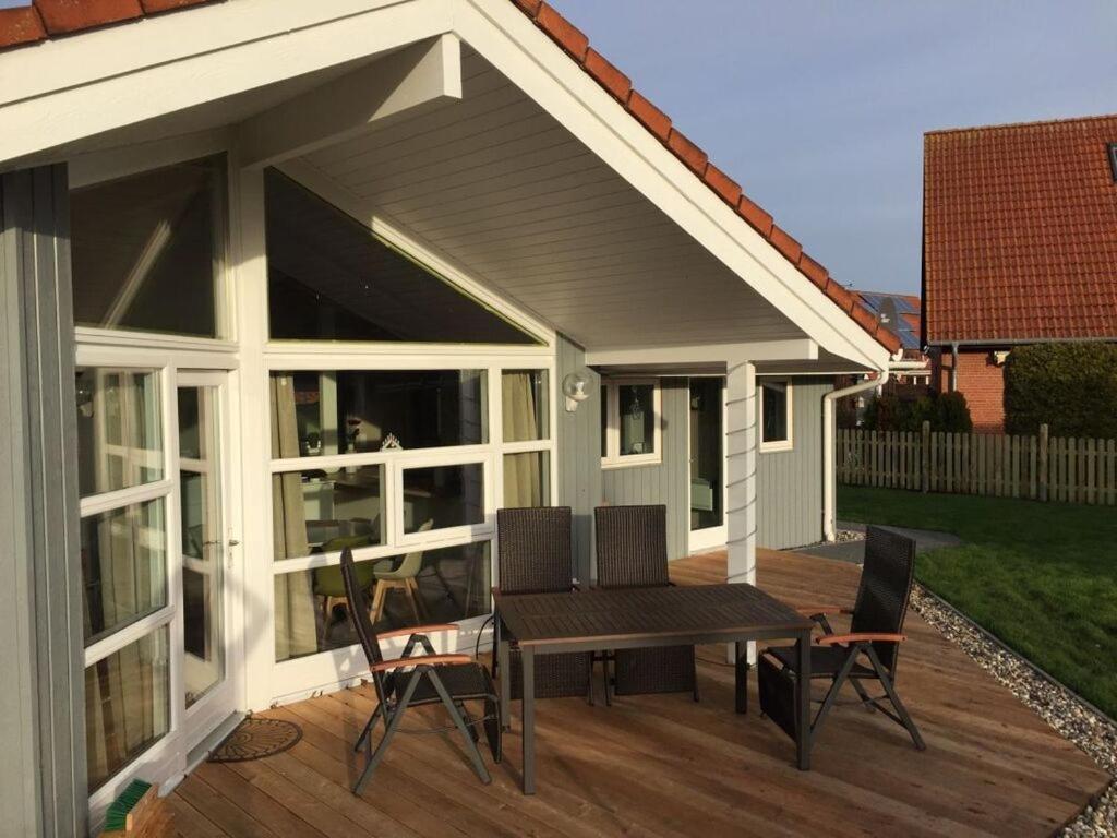 a patio with a table and chairs on a deck at Holiday home Dan Huus Marie in Großenbrode