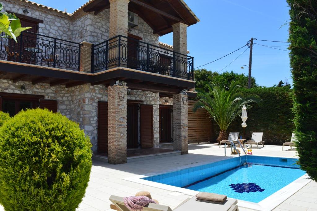 a villa with a swimming pool and a house at Julieta Stone Villa in Andip&aacute;ta Er&iacute;sou