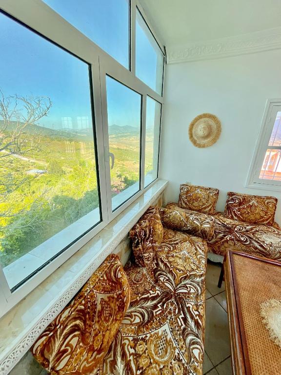 a living room with a couch and two windows at Dar Bakkali Nadi in Tangier