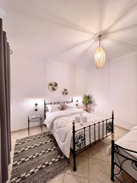 a bedroom with a large bed and a chandelier at Dar Bakkali Nadi in Tangier