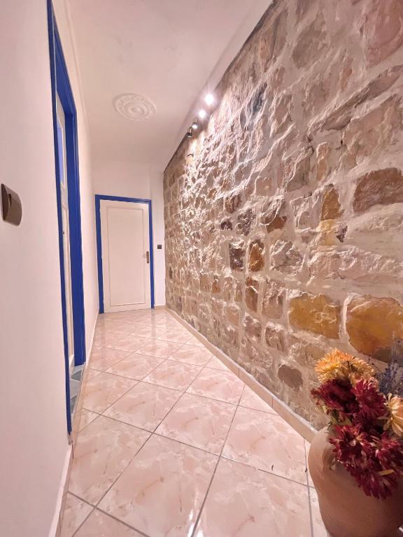 a hallway with a stone wall and a vase with flowers at Dar Bakkali Nadi in Tangier