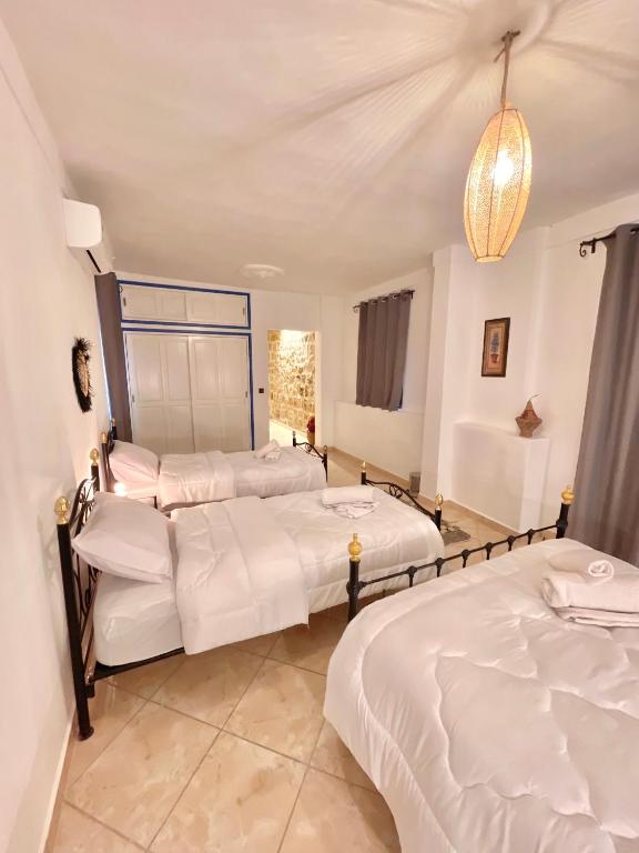 a room with three beds and a chandelier at Dar Bakkali Nadi in Tangier