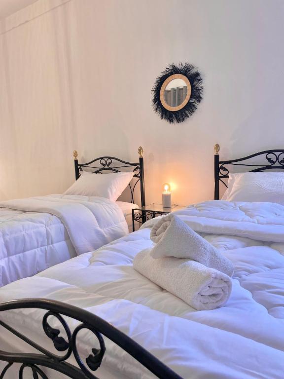 a bedroom with two beds with white towels and a mirror at Dar Bakkali Nadi in Tangier