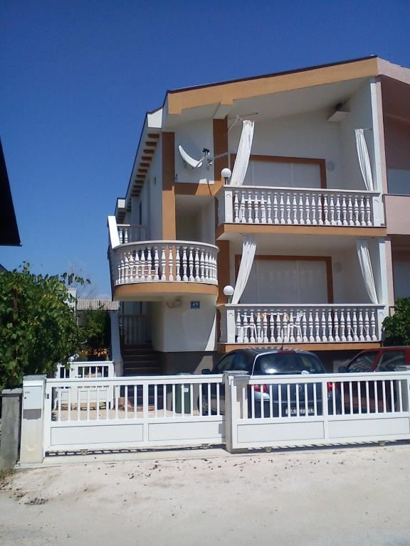 a house with a white fence in front of it at Apartman Mira Sabunike 1 in Privlaka