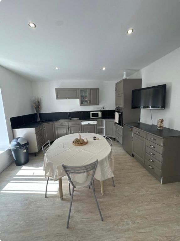 une cuisine avec une table blanche et une cuisine avec dans l'établissement Appartement T3, à Marseillette