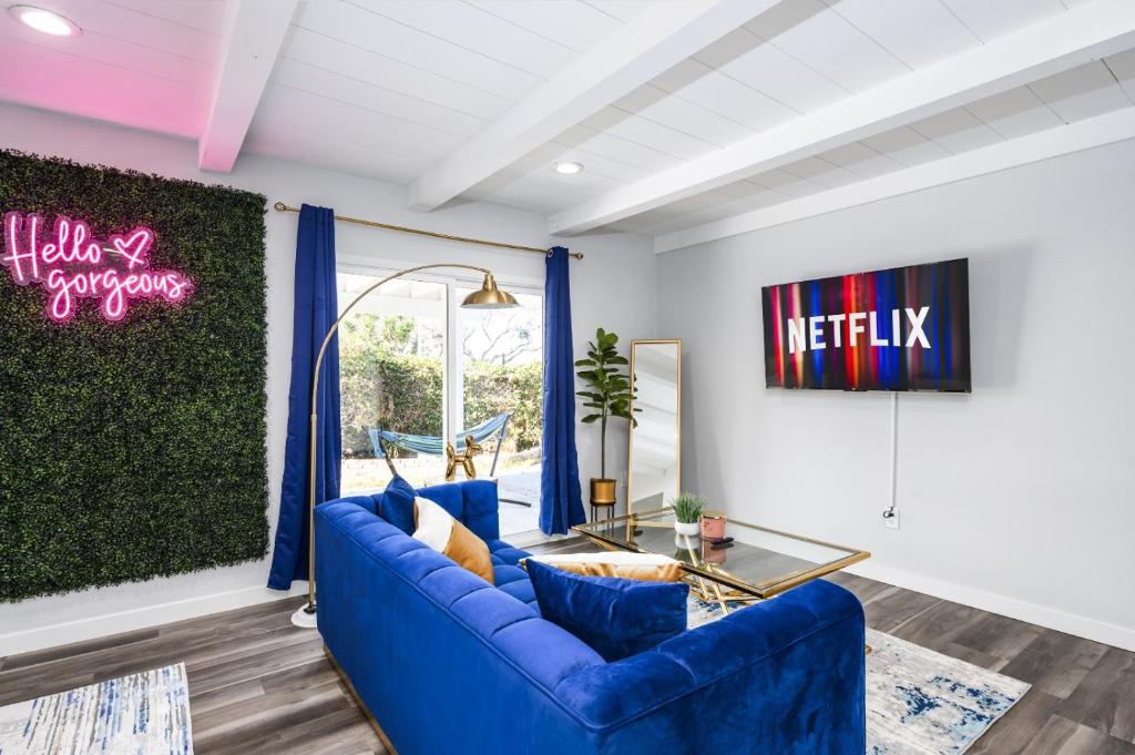 ein Wohnzimmer mit einem blauen Sofa und einem Tisch in der Unterkunft Luxury 4 Bedroom House Mins to Disney! Game Room in Westminster