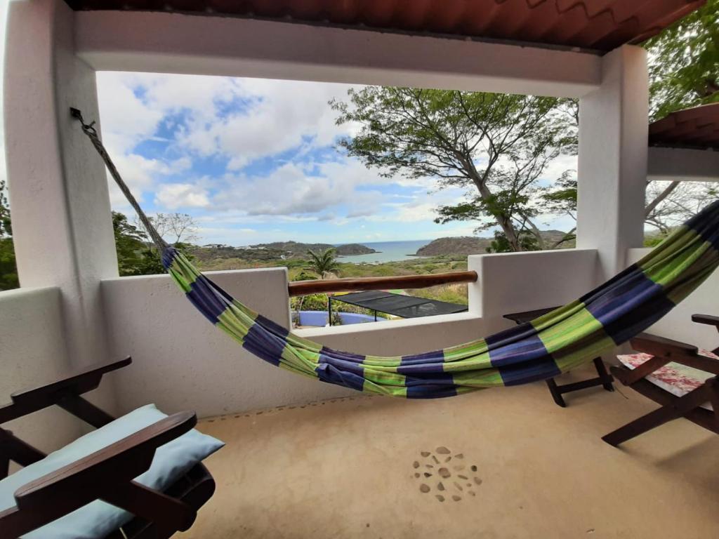 un hamac sur un porche avec vue sur l'océan dans l'établissement El Jardin, à San Juan del Sur