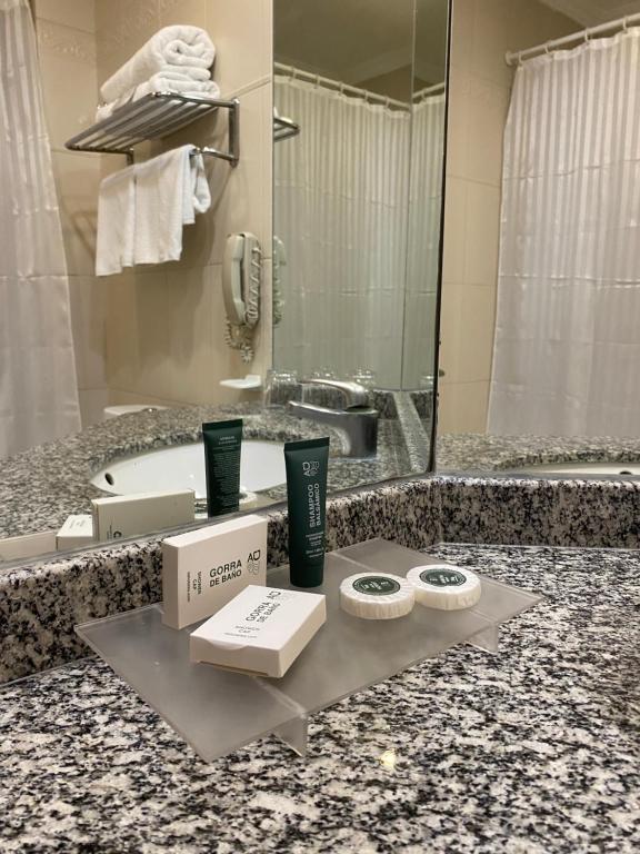 a bathroom with a counter with a sink and a tub at Hotel Diego de Almagro Aeropuerto in Santiago