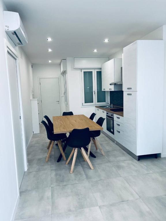a kitchen with a wooden table and chairs at MK Apartments in Lido di Jesolo