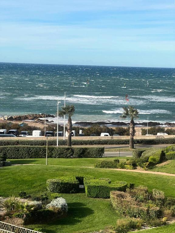un parc avec vue sur l'océan avec des palmiers dans l'établissement Résidence Morieres B - Super appartement 4 couchages dans le domaine de la Coudoulière MAE-7334, à Six-Fours-les-Plages