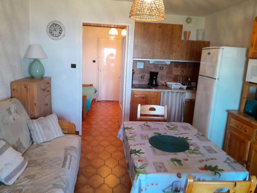une petite cuisine avec une table et un réfrigérateur dans l'établissement Résidence Marines D'aryana - Appartement 5 couchages proche plage dans résidence avec piscine MAE-3651, à Six-Fours-les-Plages