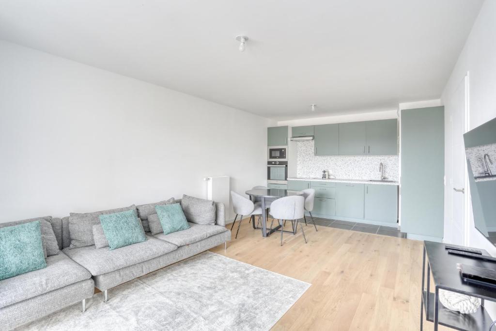 un salon avec un canapé et une table dans l'établissement C est Votre Maison, à Rueil-Malmaison