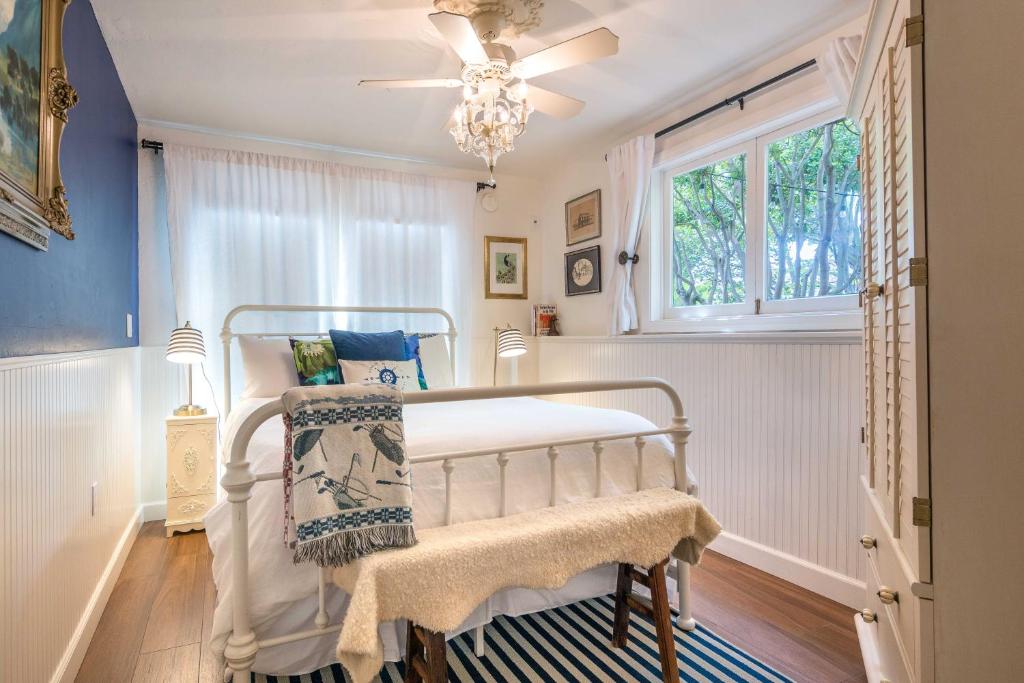 a bedroom with a bed with a window and a chandelier at Redwood Hollow Cottages in San Diego