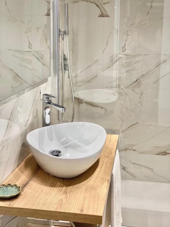 a bathroom with a white sink and a shower at Feel Boutique Rooms in Oristano