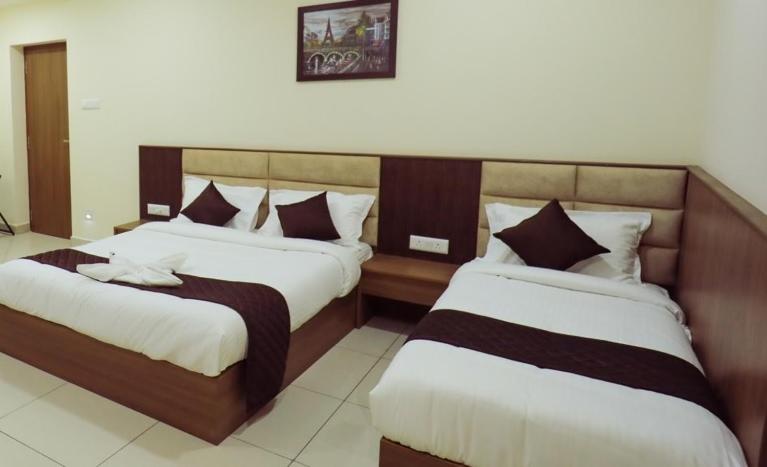 a hotel room with two beds in a room at JKInn in Vellore