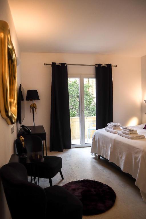 a bedroom with a bed and a sliding glass door at The White Knight Premium Boutique Hotel in Għajnsielem